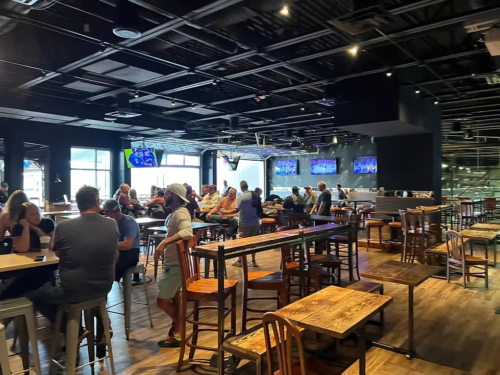 The long room at The Stable Bar & Grill on a club night, tables pushed together with boards set up and players seated along both sides.